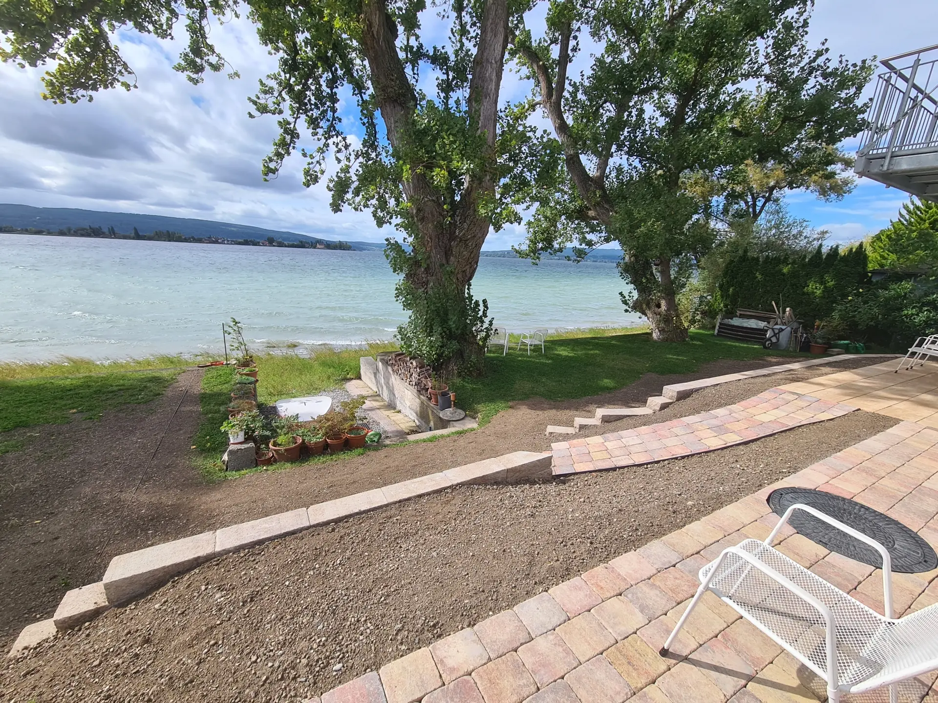 Fertige Gartenneuanlage am Seegrundstück mit Terrasse, Gartenweg und Natursteinmauern